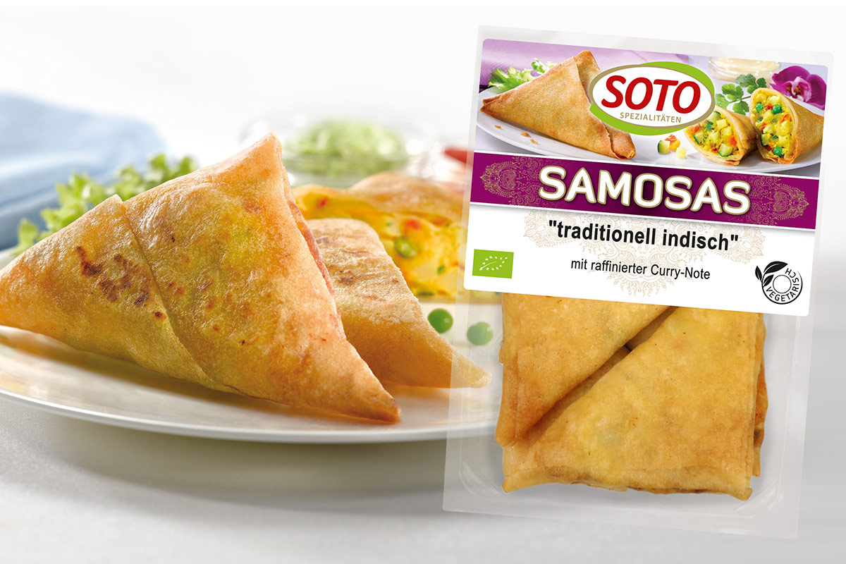 Packung SOTO Samosas „traditionell indisch“ neben goldbraunen Teigdreiecken auf dem Teller